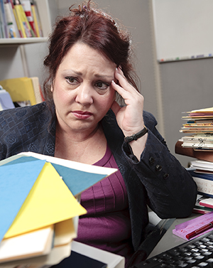 Woman in office looking stressed.