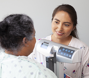 Healthcare provider weighing woman.