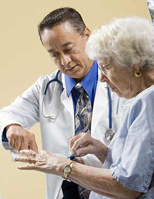 Healthcare provider talking to patient in exam room.