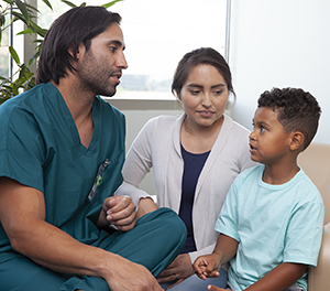 Healthcare provider talking to woman and boy.