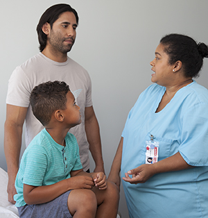 Healthcare provider talking to man and boy.