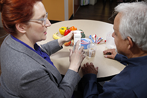 Healthcare provider showing man nutrition label on food package.