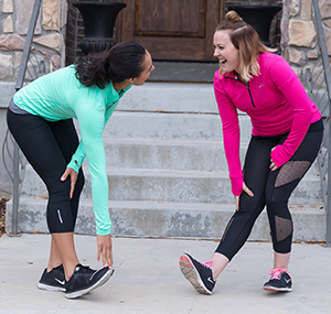 Two women stretching outdoors.