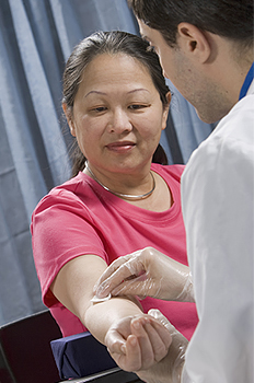 Woman having blood drawn by phlebotomist.