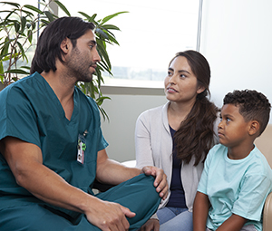 Un proveedor de atención médica habla con una mujer y un niño.