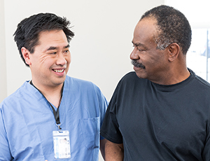 Healthcare provider talking to man in exam room.