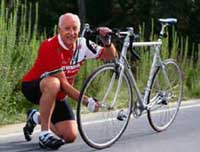 Photo of an older man adjusting his bicycle wheel