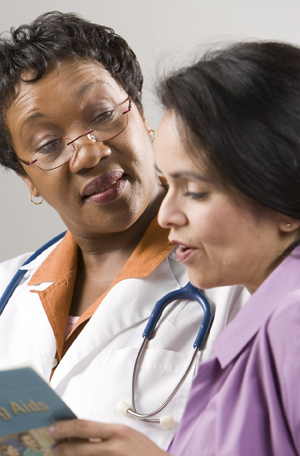 Woman looking at patient education brochure with health care provider.