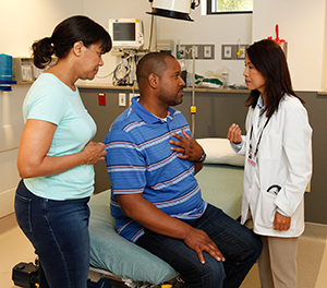 Man and woman in emergency room talking to healthcare provider.