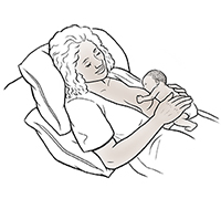 Woman breastfeeding premature baby in laid-back position.