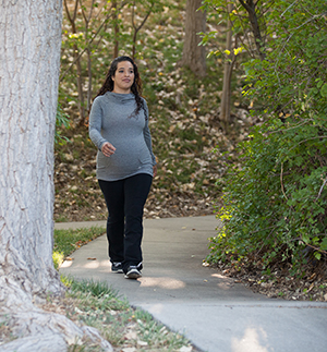 Pregnant woman outdoors walking.