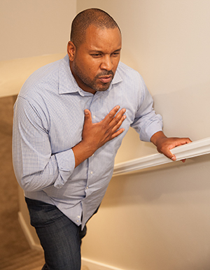 Man walking upstairs holding hand to chest.