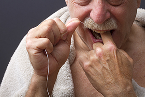 Man flossing teeth.